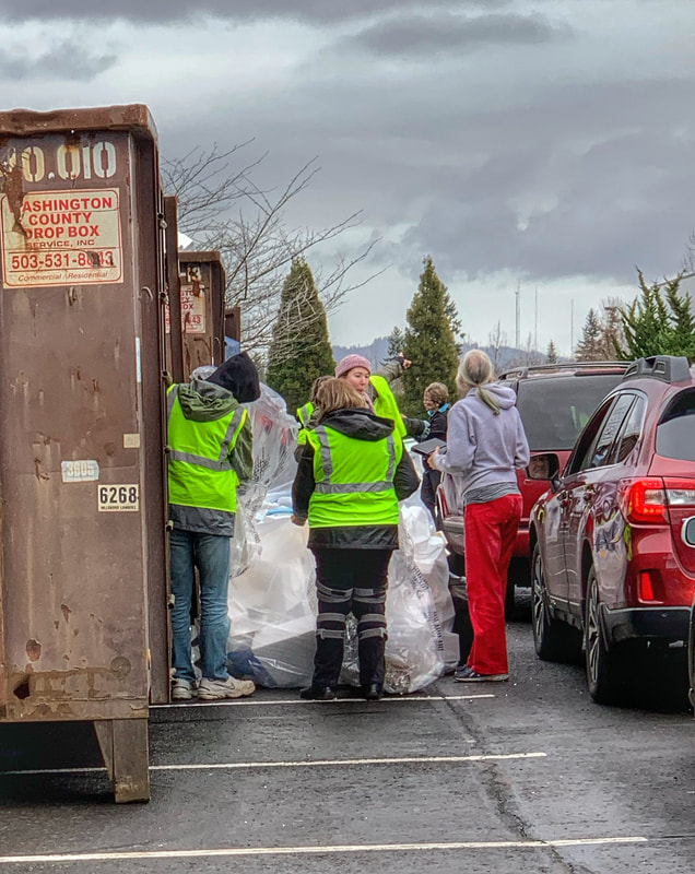 Volunteers collect styrofoam from guests in a line of cars